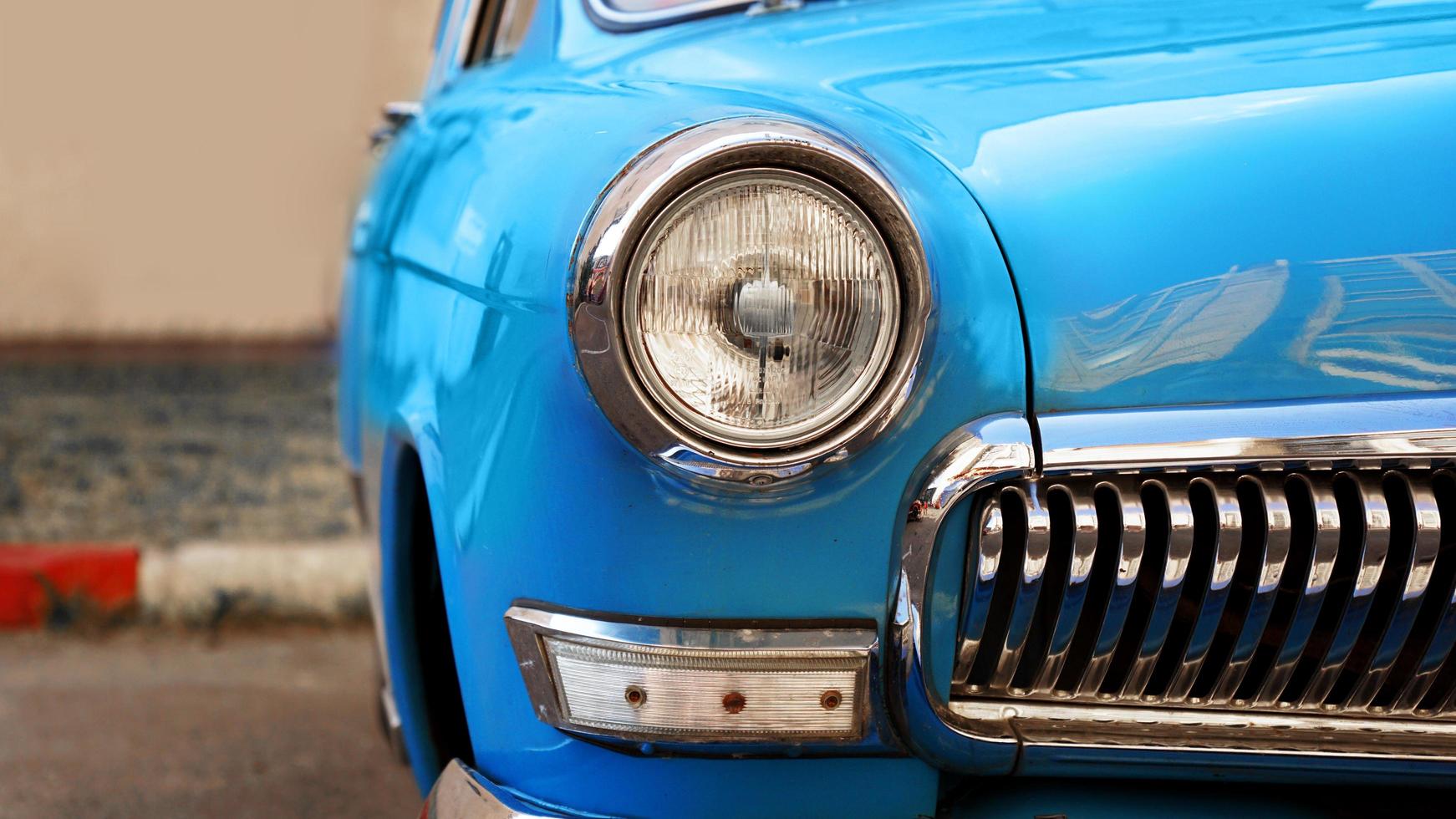 Blue retro car. Old vintage car. Headlight close up photo