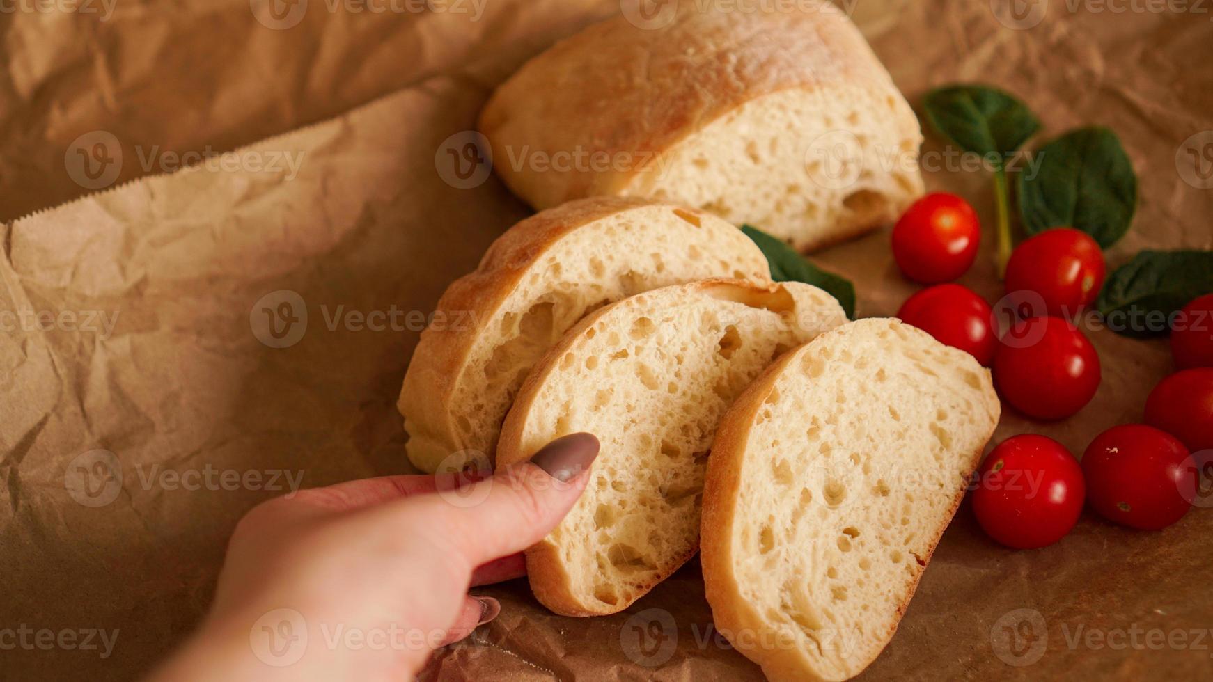 Ciabatta slices and cherry tomatoes on craft paper. photo