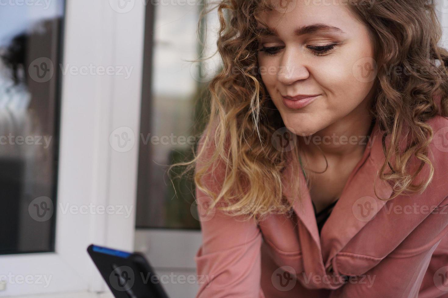 alegre, hermosa, mujer joven, con, pelo rizado, con, smartphone foto