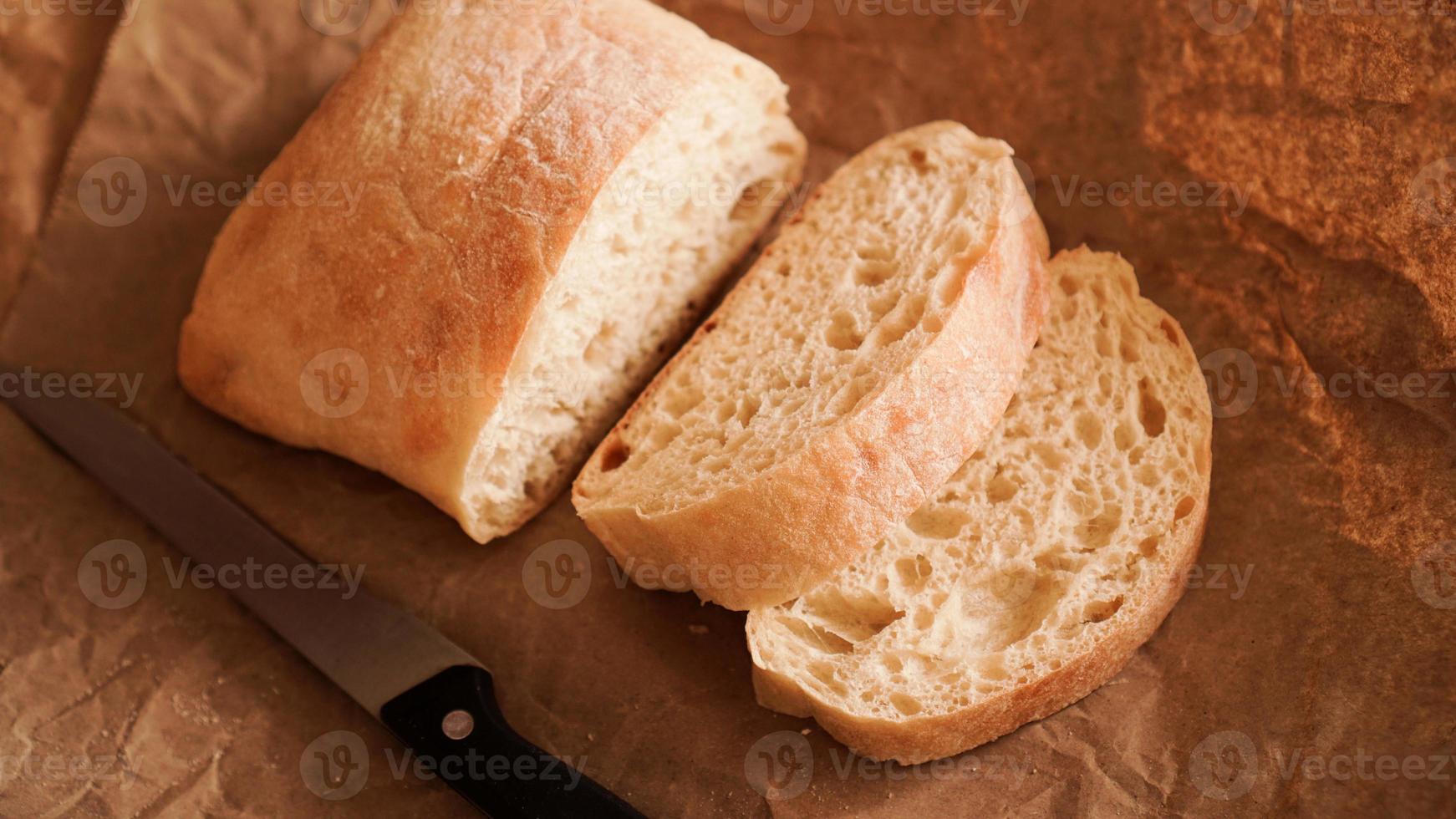 el chef corta la chapata con un cuchillo. ciabatta foto