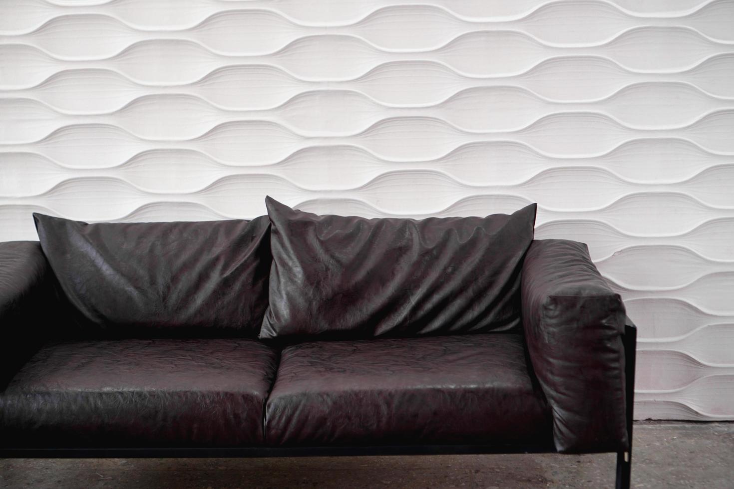 Black leather sofa on white background in studio photo