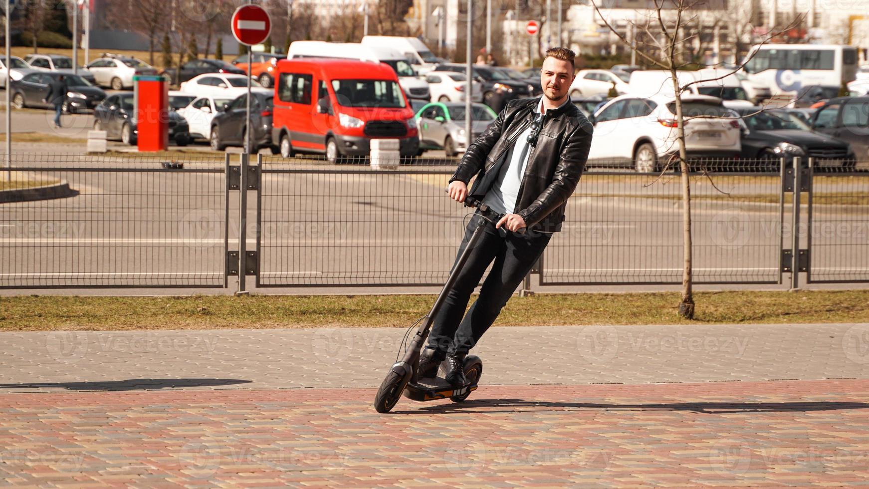 Hombre moderno montando scooter eléctrico en la ciudad foto