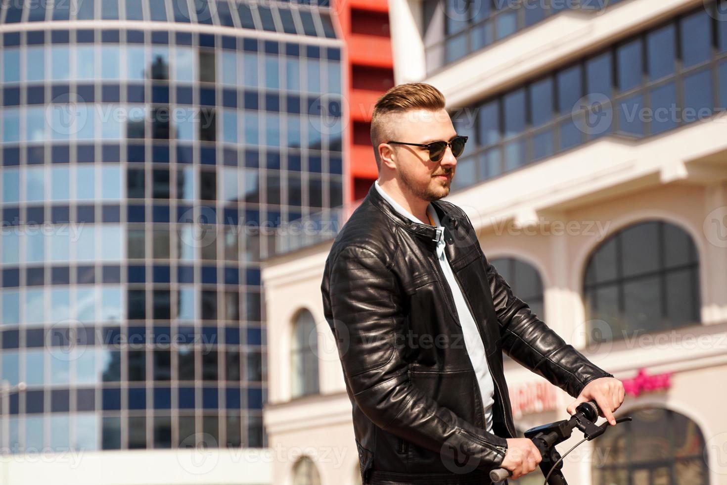 Modern man riding electric scooter in the city photo