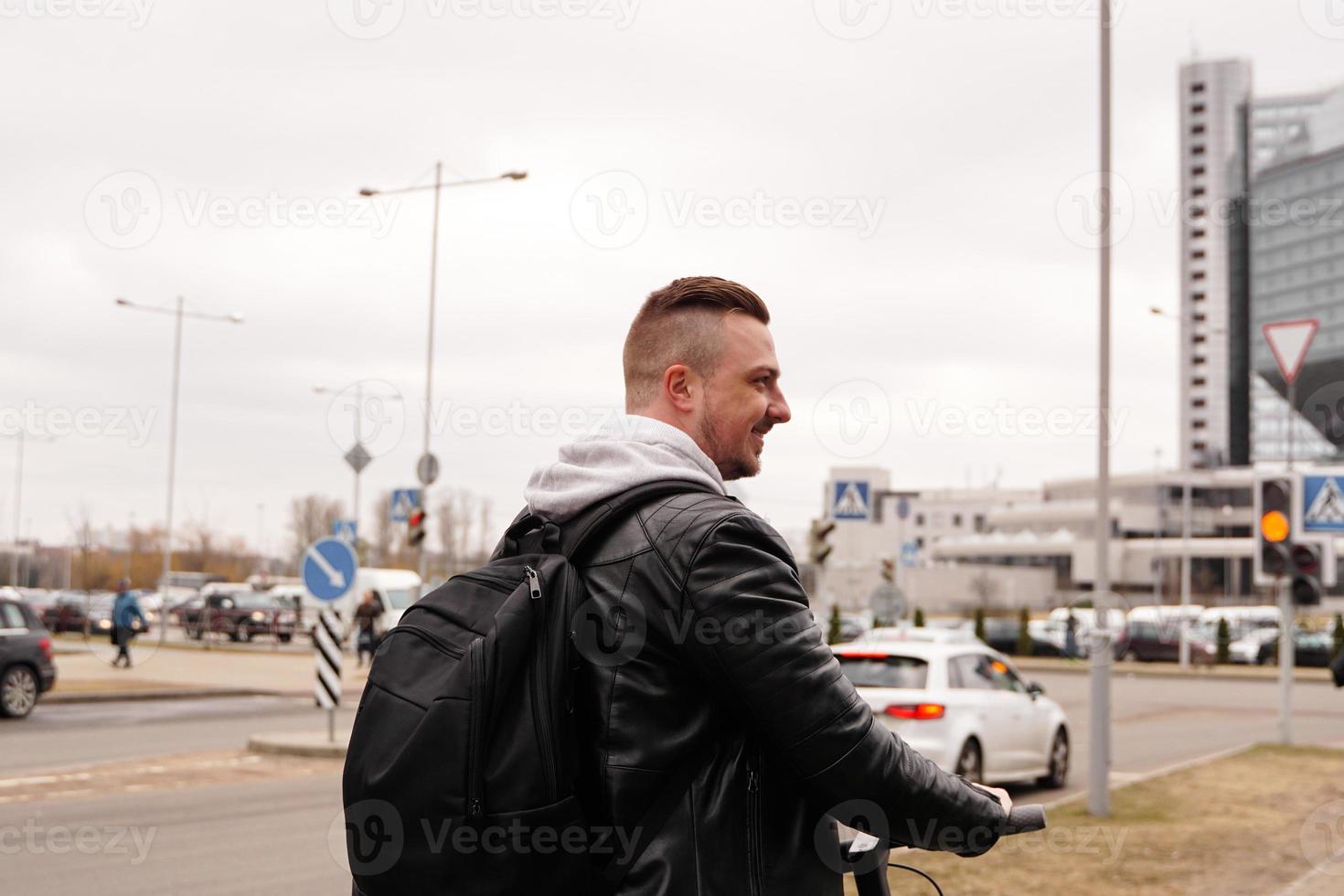 Young man with backpack on his back riding on scooter photo