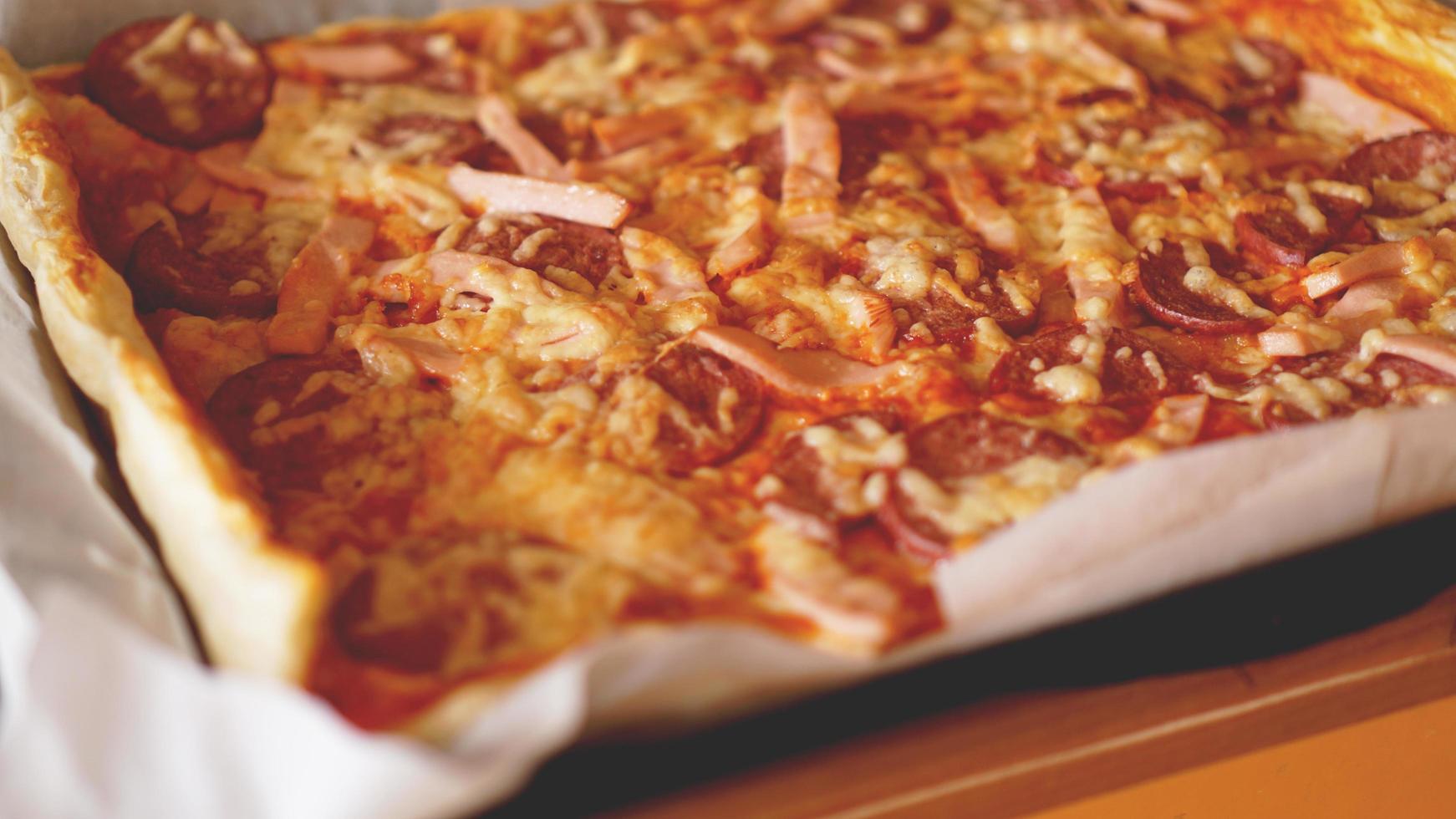 Pizza casera en una mesa de madera rústica. foto