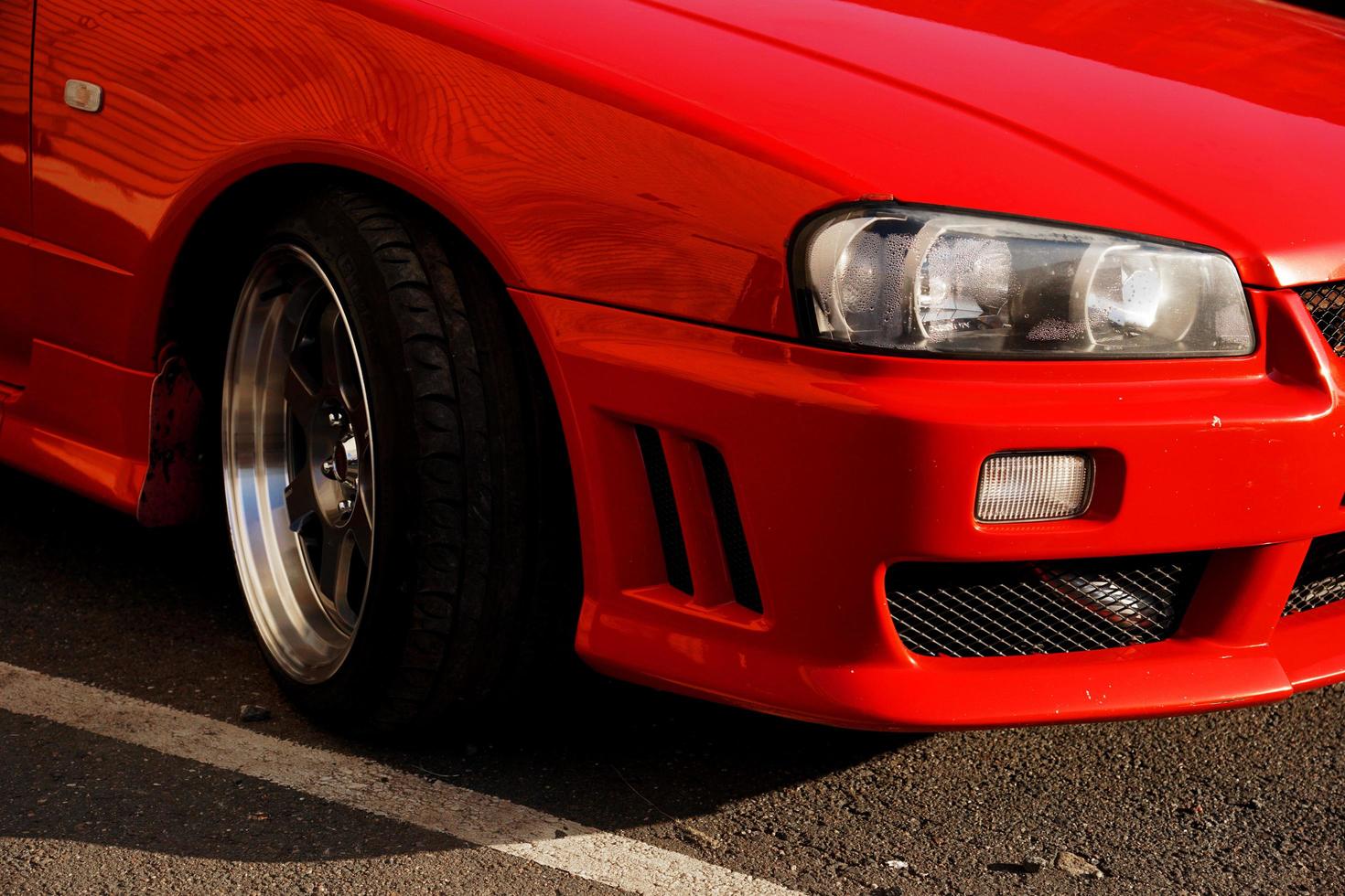 Red retro car. Old vintage car. Headlight close up photo