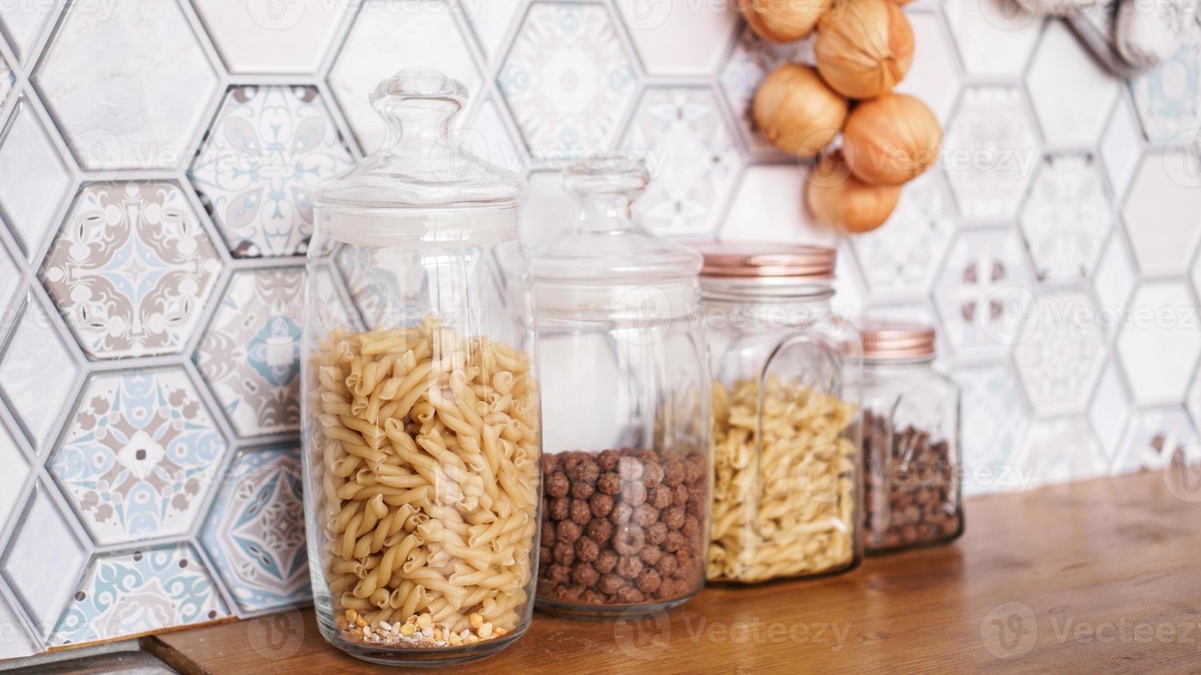 Pasta in glass jars. Pasta on a wooden countertop photo