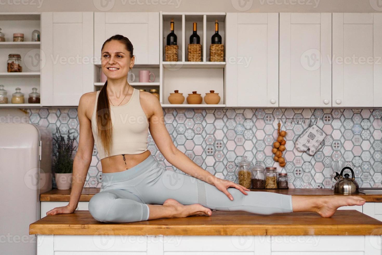 Mujer atlética en ropa deportiva posando sobre la mesa foto