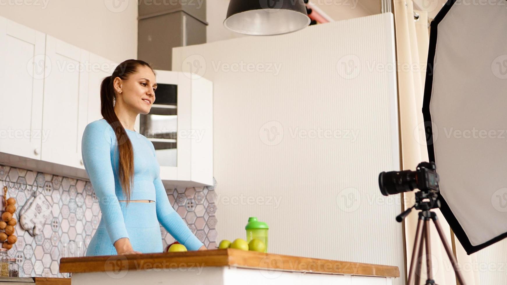 A woman in a tracksuit records a video blog photo