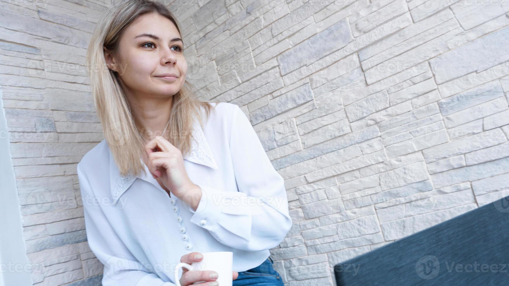 vista lateral. mujer de negocios joven con una taza de café y un cuaderno. foto