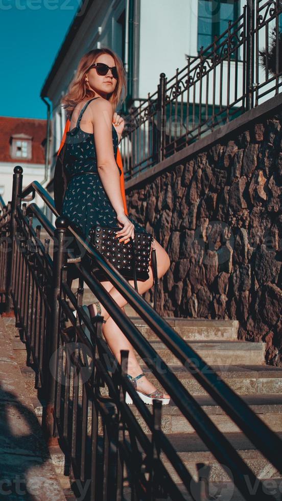 Woman in dress walks through the old city streets on a sunny day photo