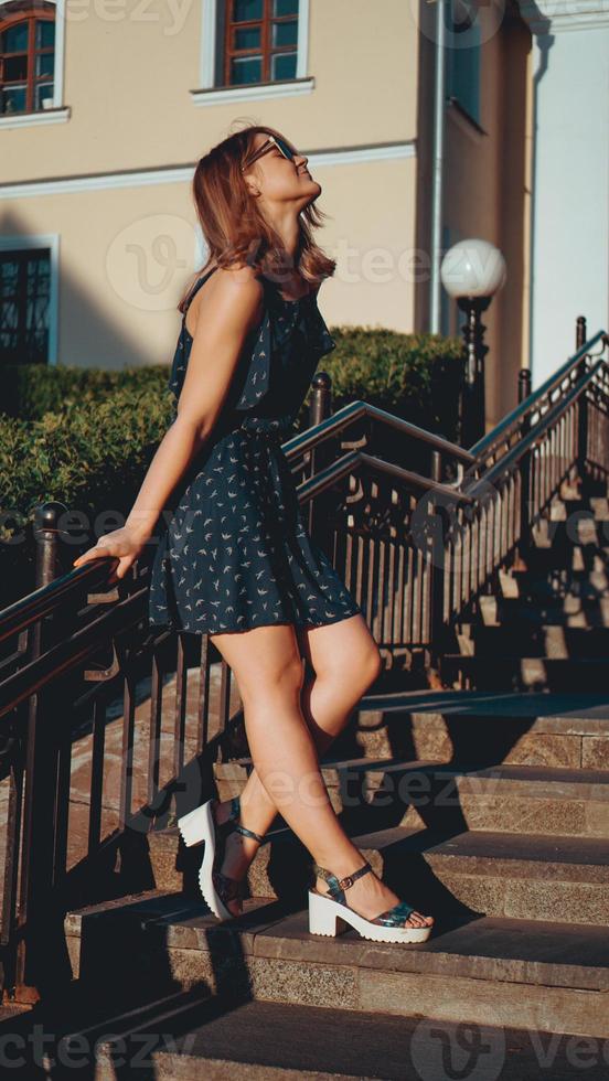 Woman in dress walks through the old city streets on a sunny day photo