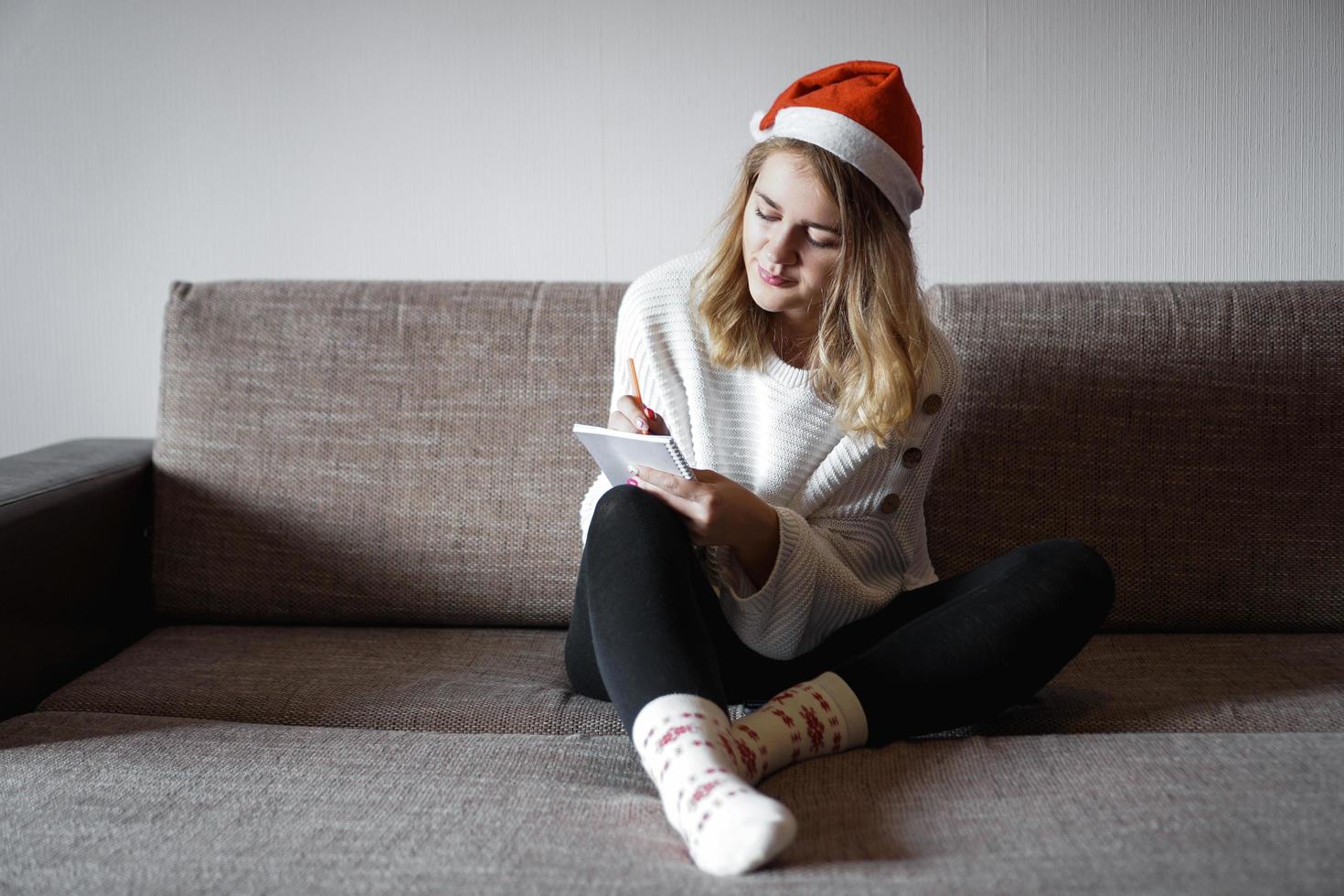 retrato de niña bonita en navidad escribe planes para el año nuevo foto