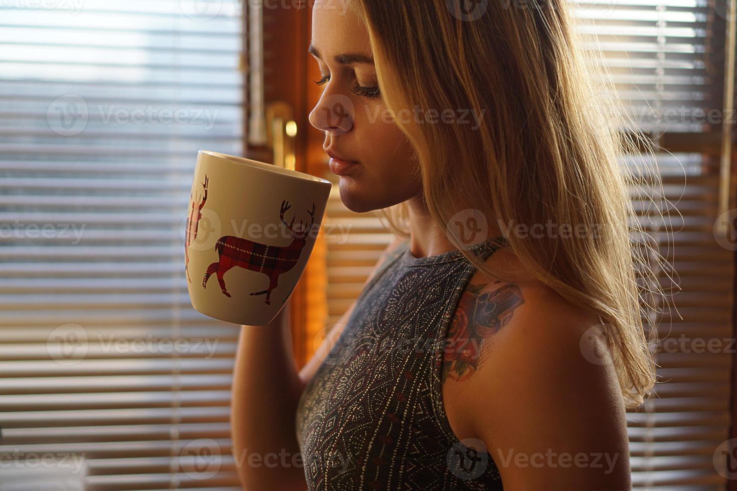 mujer joven, cerca de la ventana, con, un, taza de té foto