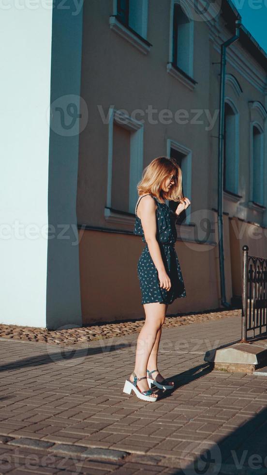 Mujer vestida camina por las calles de la ciudad vieja en un día soleado foto