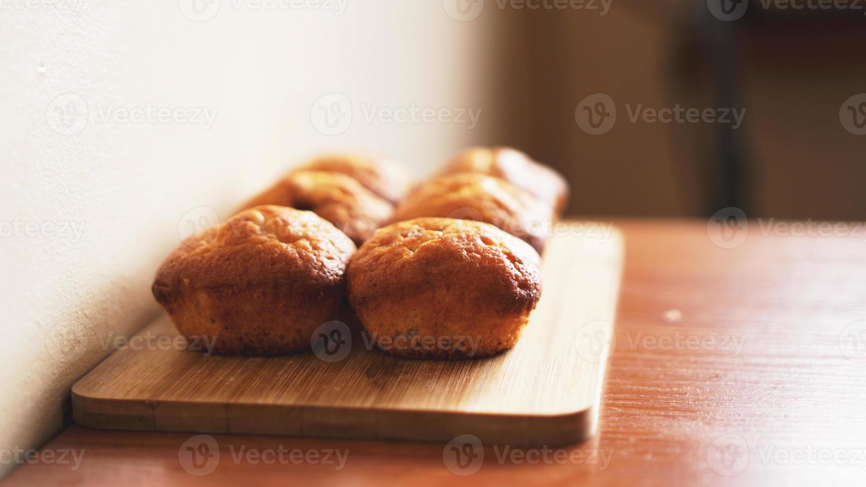 Six delicious home-made muffins on a wooden background photo