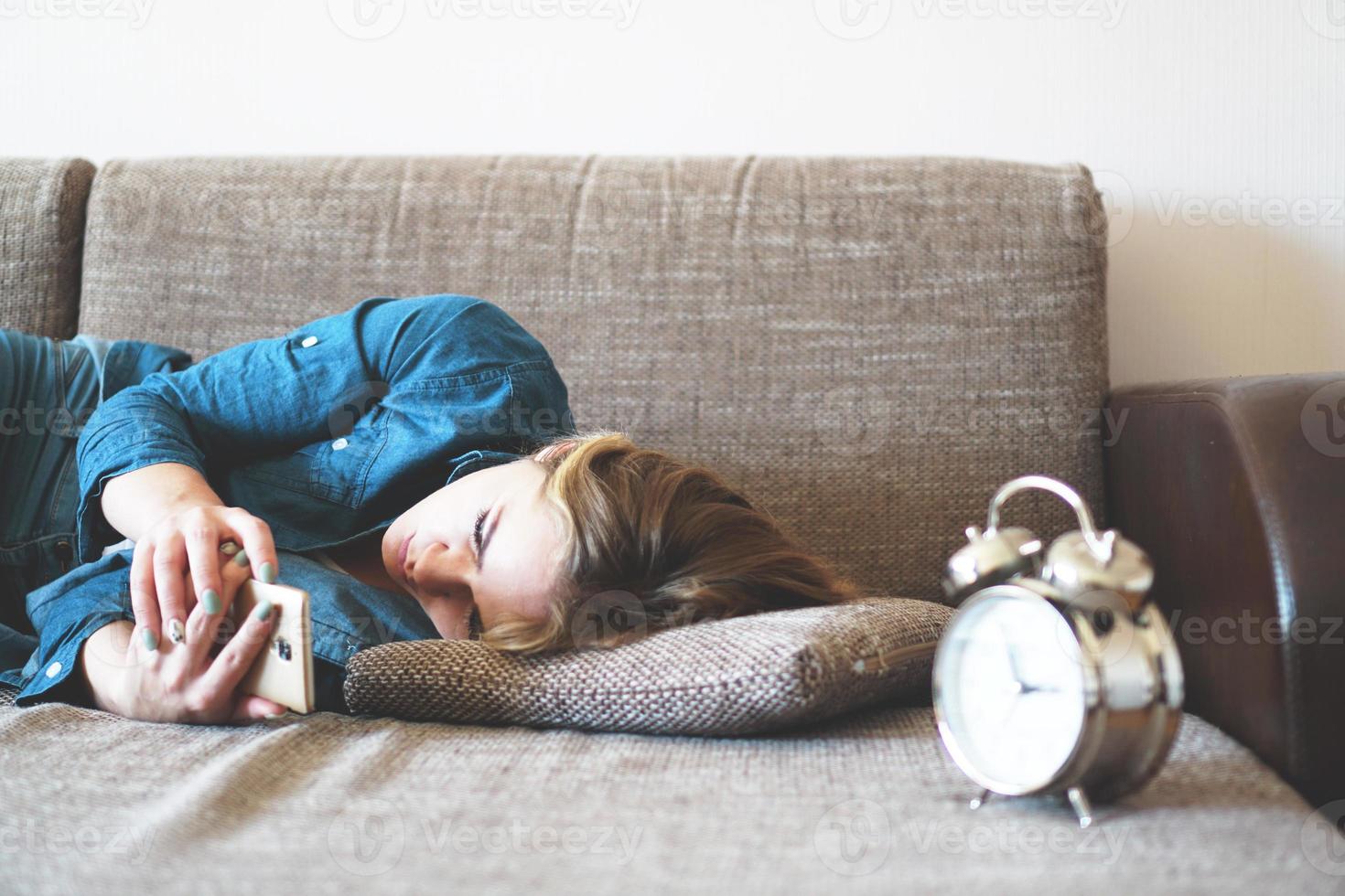 mujer joven, utilizar, teléfono, en cama, mirar la pantalla foto