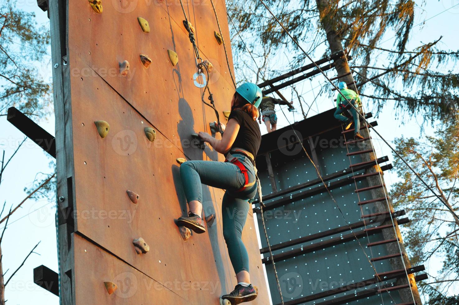 Active young woman on rock wall in sport center photo