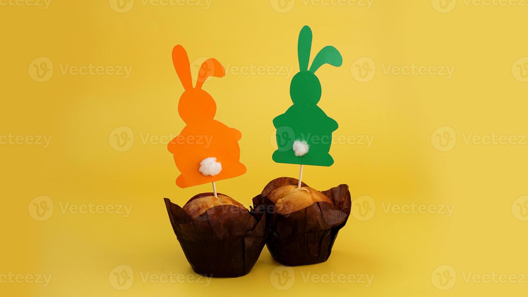 muffin decorado con un conejo de papel en un palillo. decoración de pascua foto