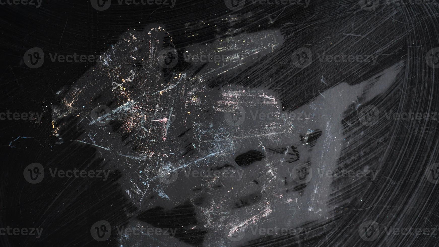 Smudged traces of colored chalk on a black board. School concept photo