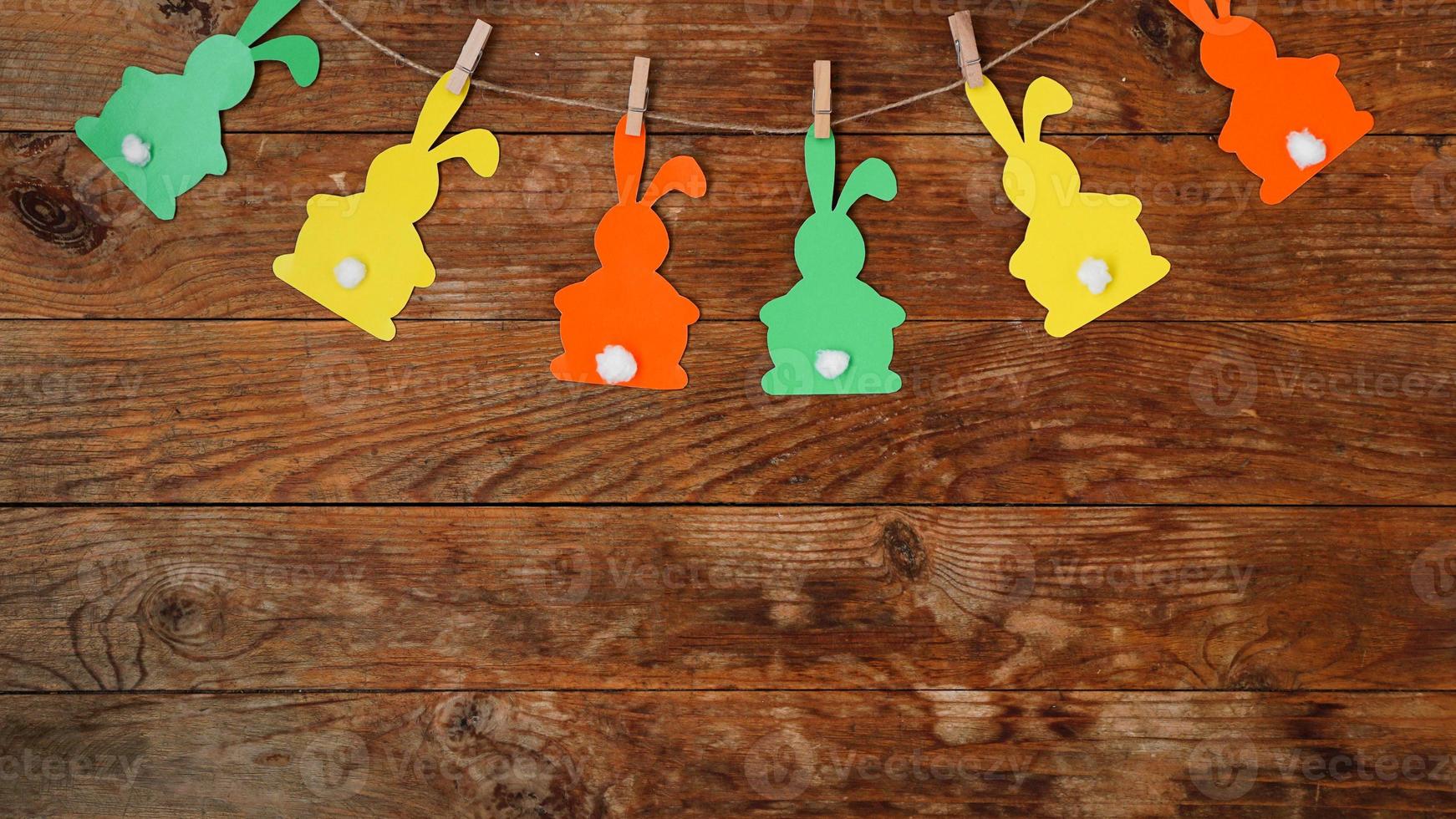 Easter background. Garland of paper rabbits on a wooden background. photo