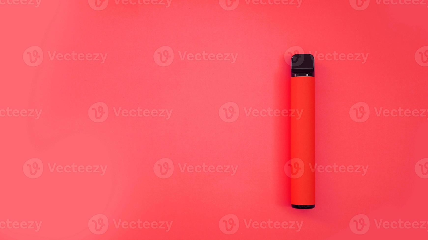 Red disposable electronic cigarette on bright red background photo