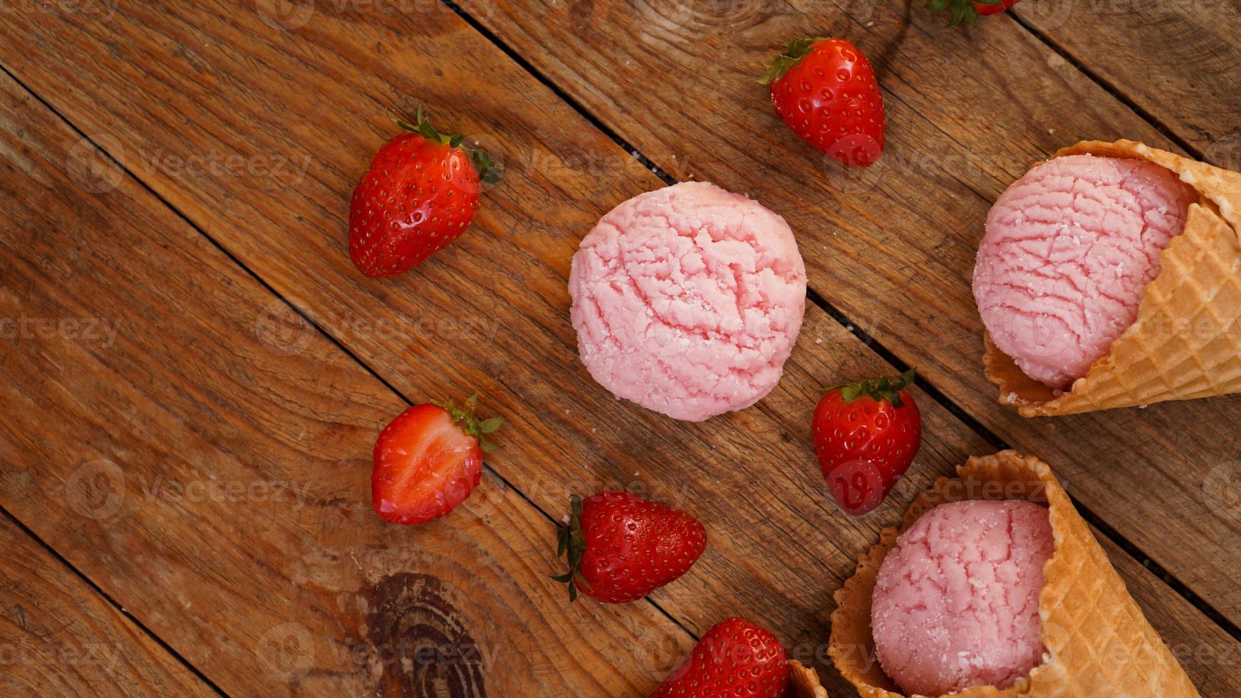 Strawberry ice cream in a waffle cone. Red berries and ice cream balls photo