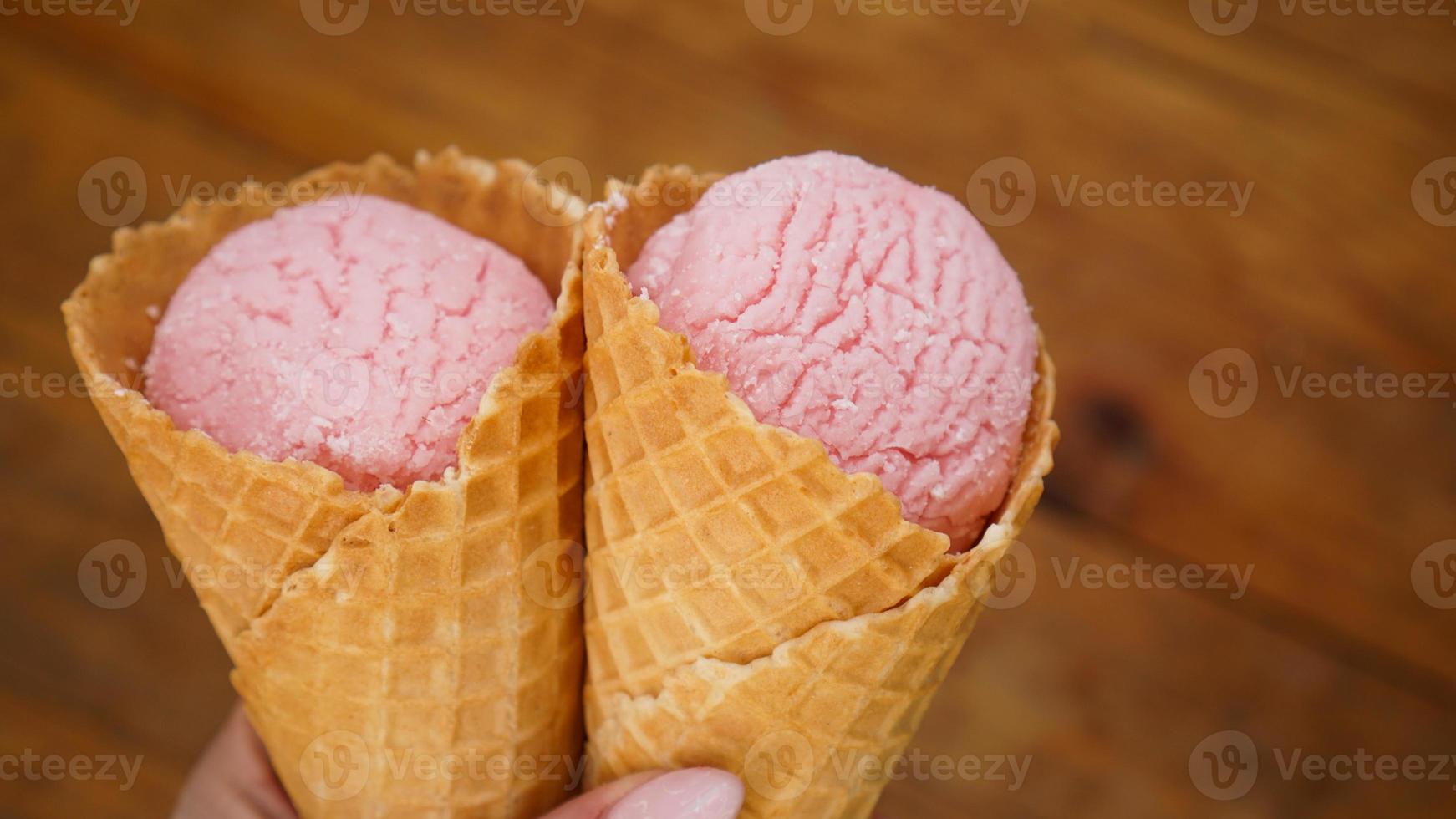 Close up image of woman hand holding two raspberry ice cream photo