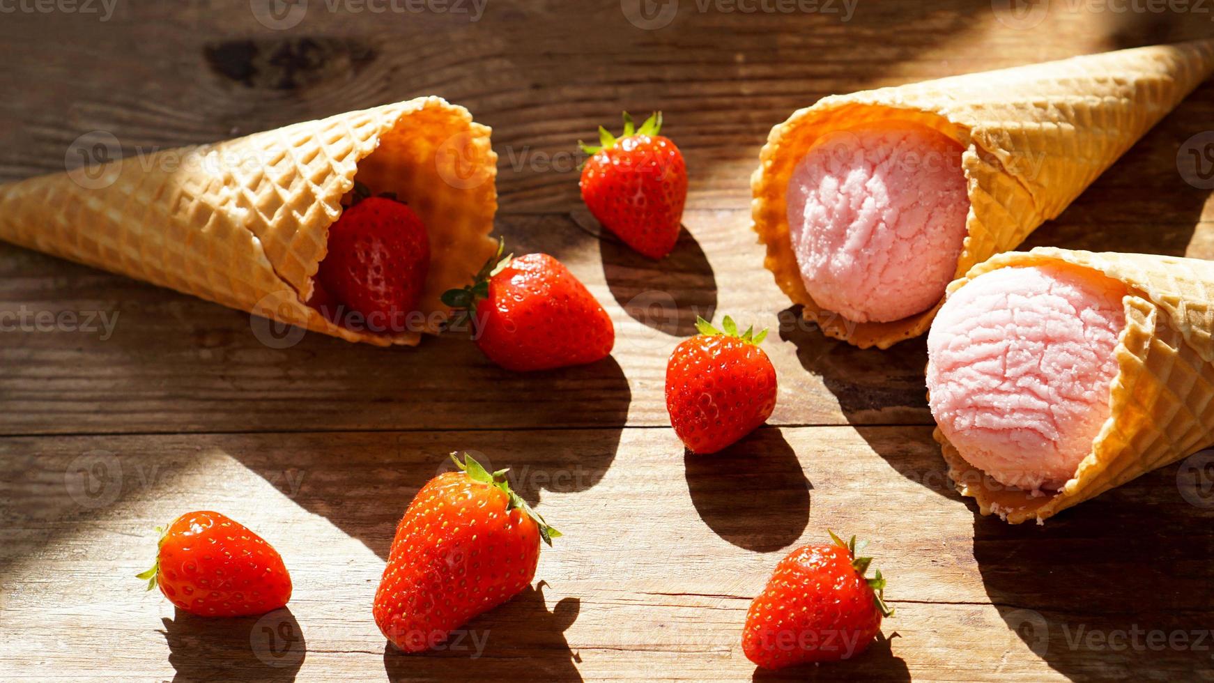 Strawberry ice cream in a waffle cone. Red berries and ice cream balls photo