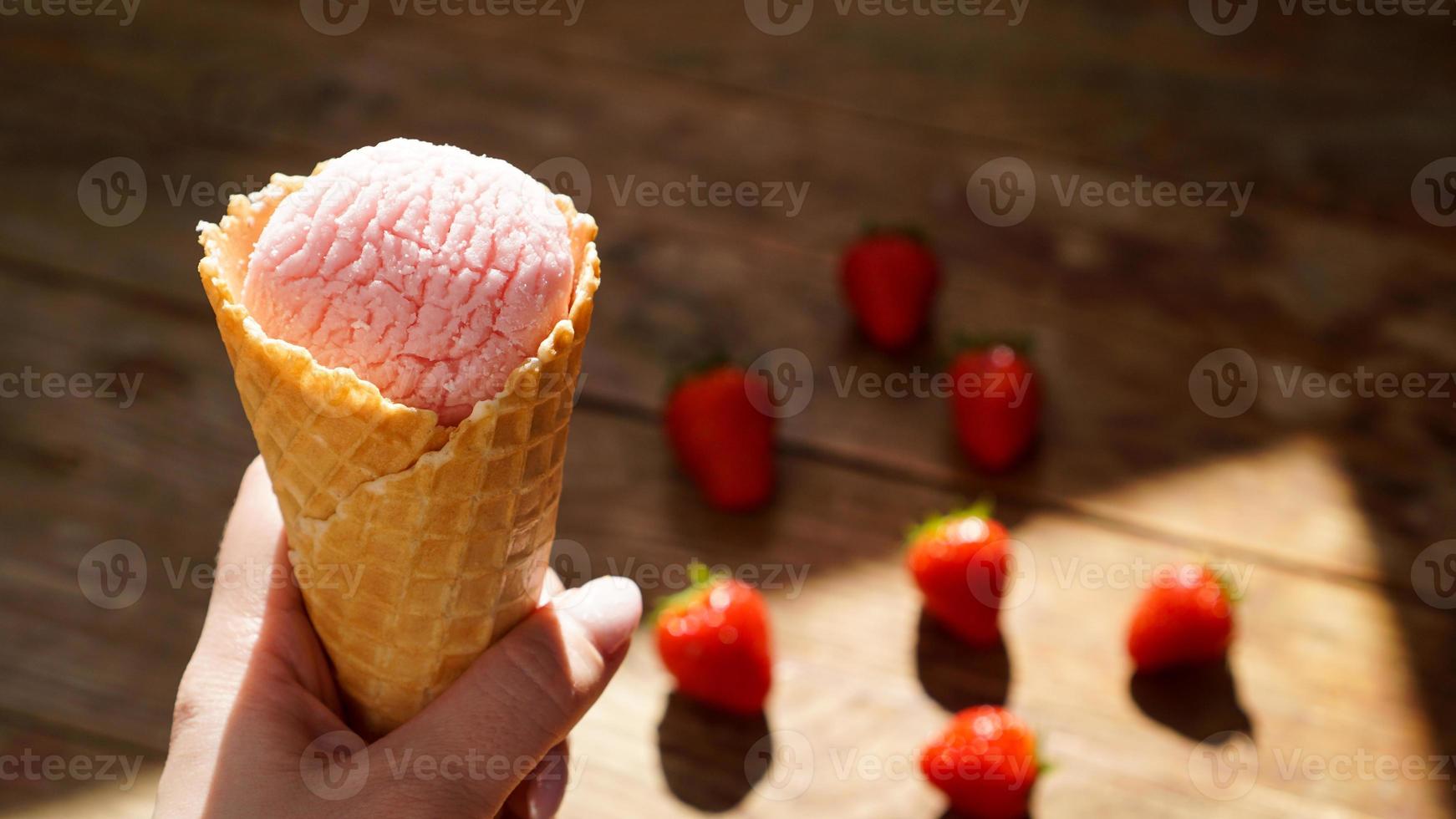 Close up image of woman hand holding raspberry ice cream photo