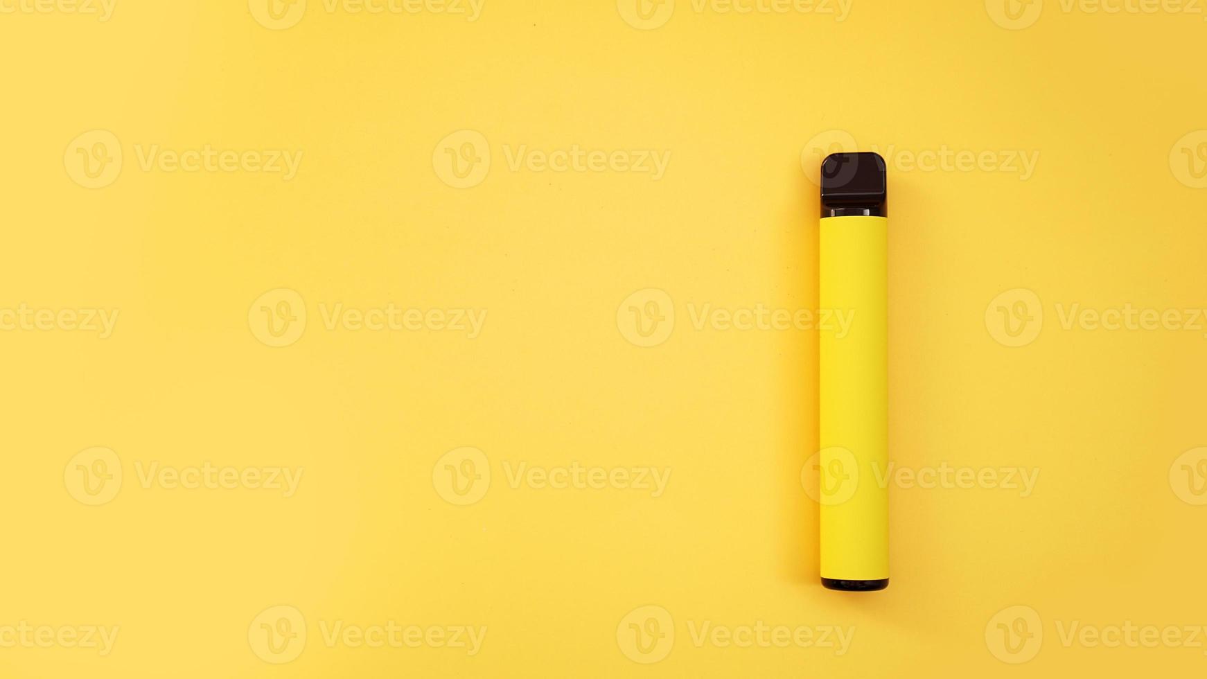 Yellow disposable electronic cigarette on bright yellow background photo