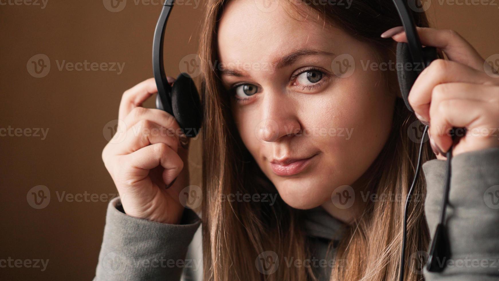 Portrait of a young girl in a hoodie and with a headset. Call center photo