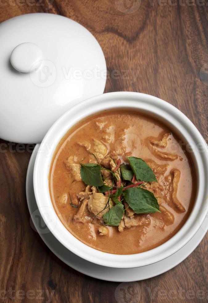 Thai spicy Panang pork curry with coconut milk on wood table in Phuket Thailand photo