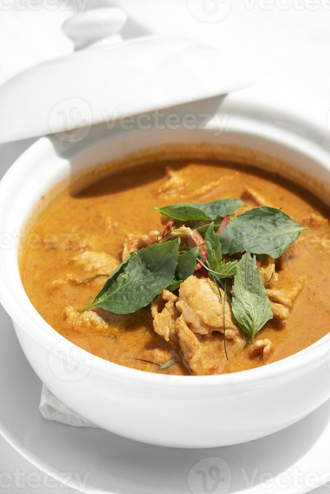 Curry de cerdo panang picante tailandés con leche de coco en la mesa de madera en Phuket, Tailandia foto