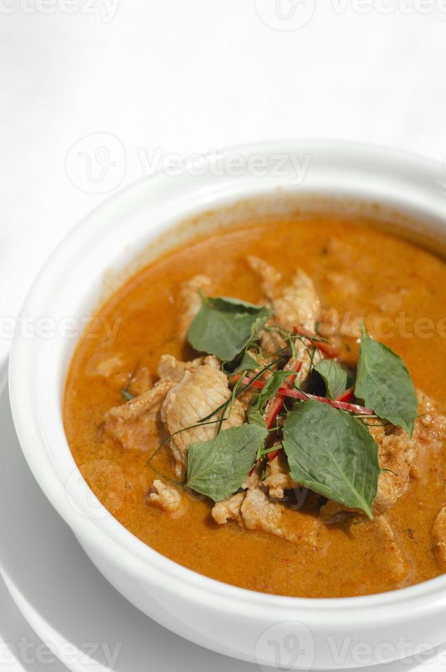 Curry de cerdo panang picante tailandés con leche de coco en la mesa de madera en Phuket, Tailandia foto