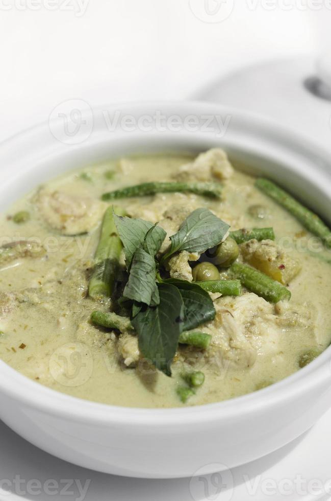 Curry verde tailandés con pollo y verduras en el fondo de la tabla blanca foto