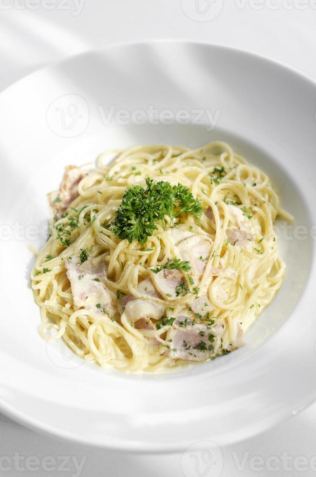 Espaguetis a la carbonara plato de pasta italiana sobre fondo blanco de la tabla foto