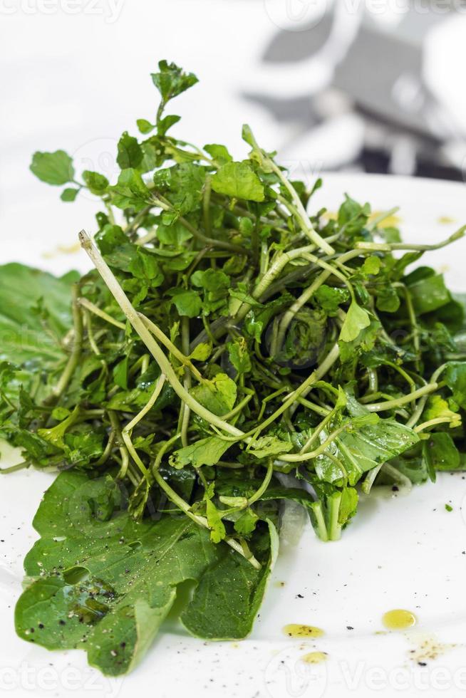 Ensalada de hojas verdes de berros y espinacas orgánicos frescos simples en un plato foto