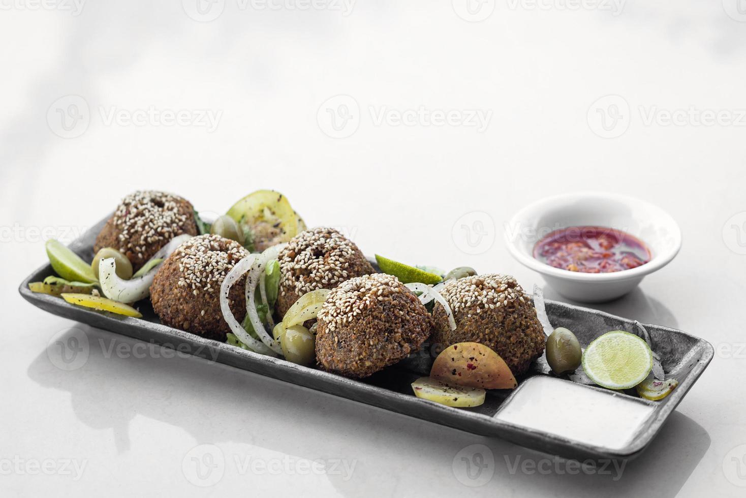 plato de falafel orgánico libanés con ensalada de pepinillos y salsas foto