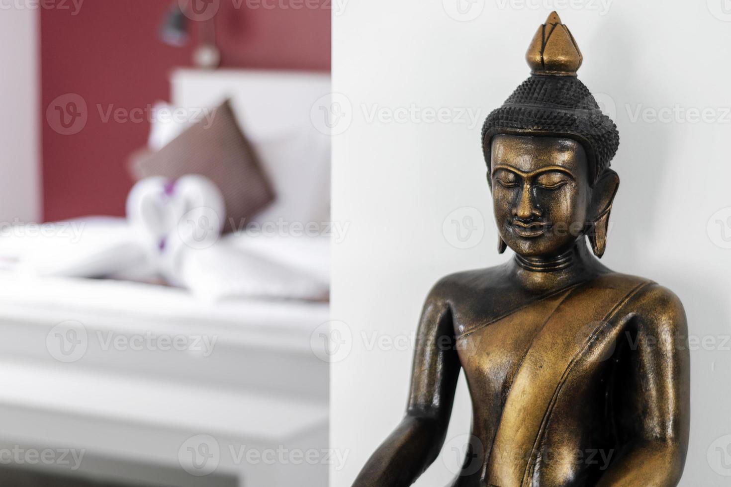 Bronze Buddha statue interior design detail in modern Asian home living room photo