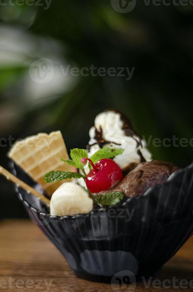 postre gourmet de helado de fresa y chocolate orgánico con cereza y plátano foto