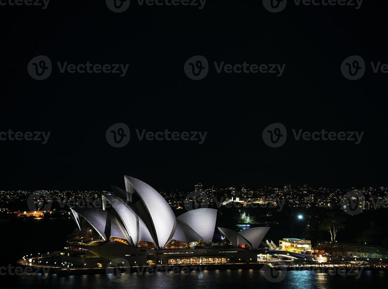 El puerto de la ciudad de Sydney con el horizonte histórico de la ópera en la noche en Australia foto