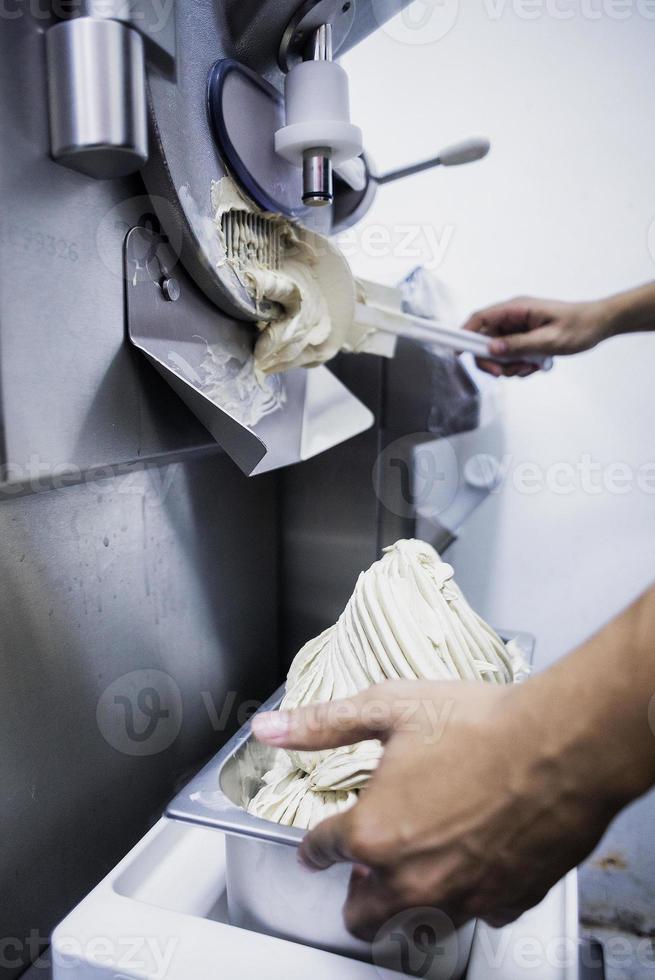 Making fresh gelato ice cream with modern machine in kitchen photo