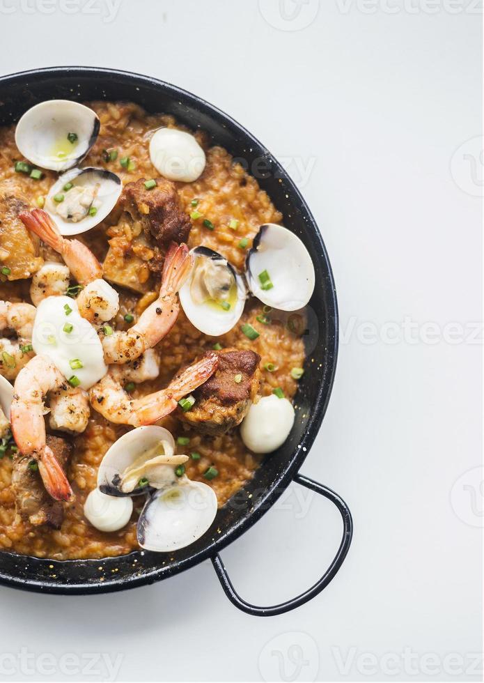 Gourmet Spanish seafood and rice paella risotto on white background photo