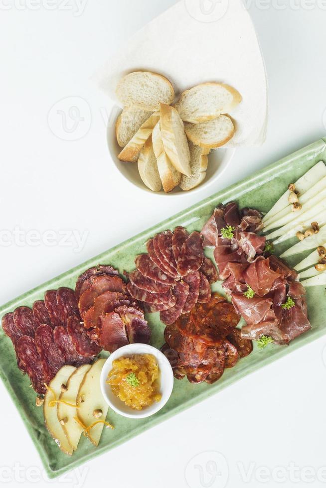 Spanish serrano ham chorizo sausage smoked meats cheese tapas sharing platter set with bread photo