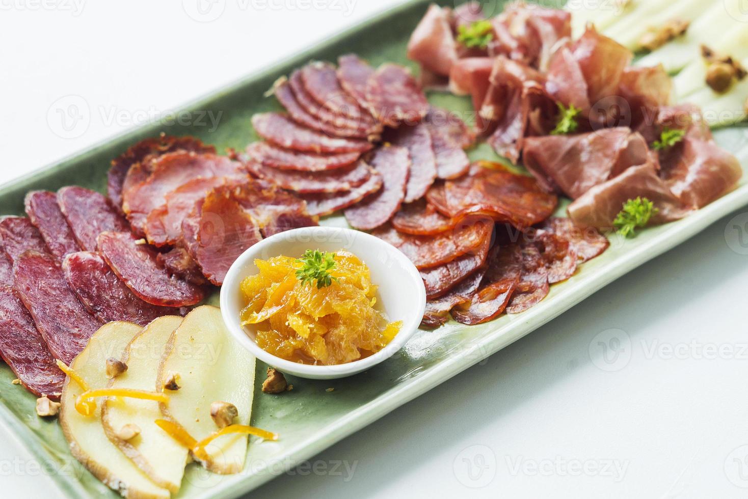 Spanish serrano ham chorizo sausage smoked meats cheese tapas sharing platter set with bread photo