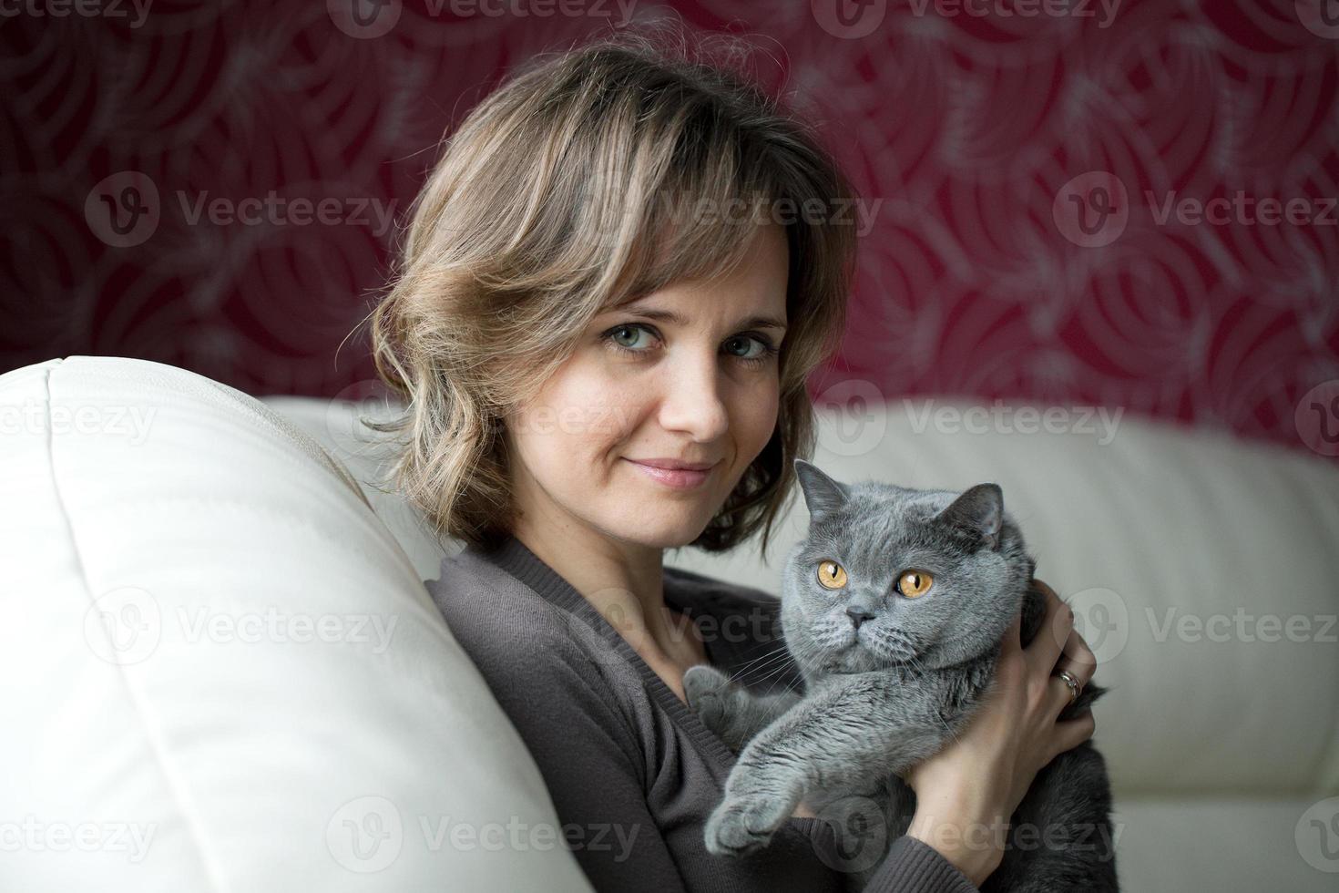 Pretty young woman caressing a cat photo