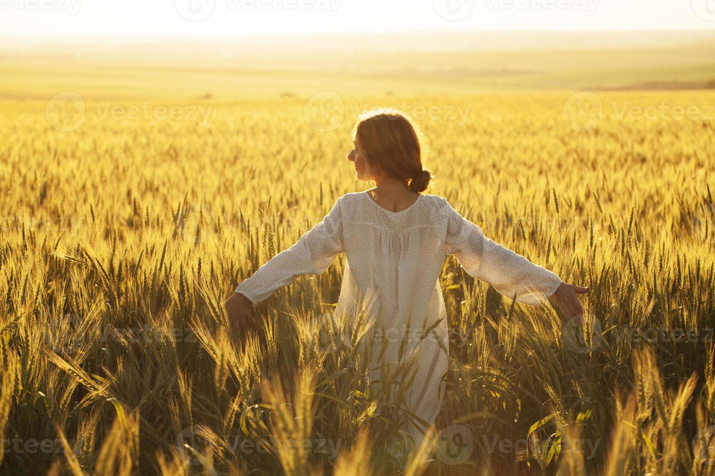Happy woman in dress in the middle of a field of ripe rye photo