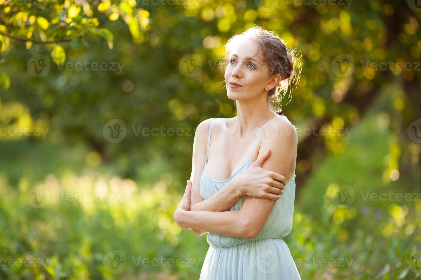 mujer bonita en vestido azul en el jardín de verano foto