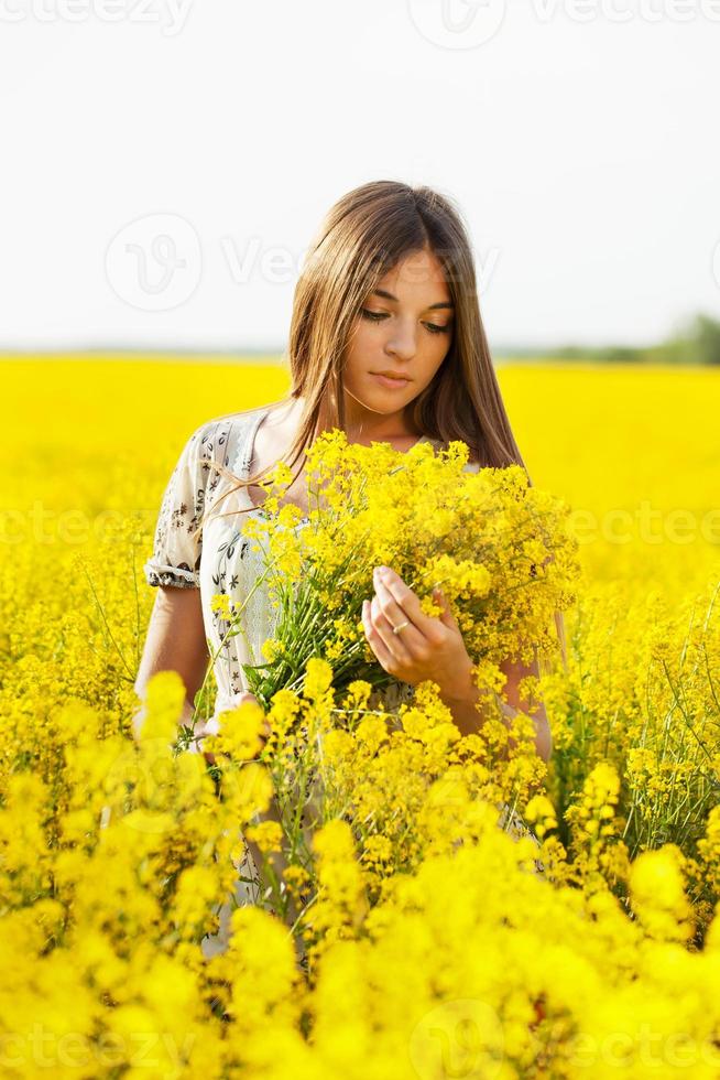 Girl holding a bouquet of yellow flowers photo